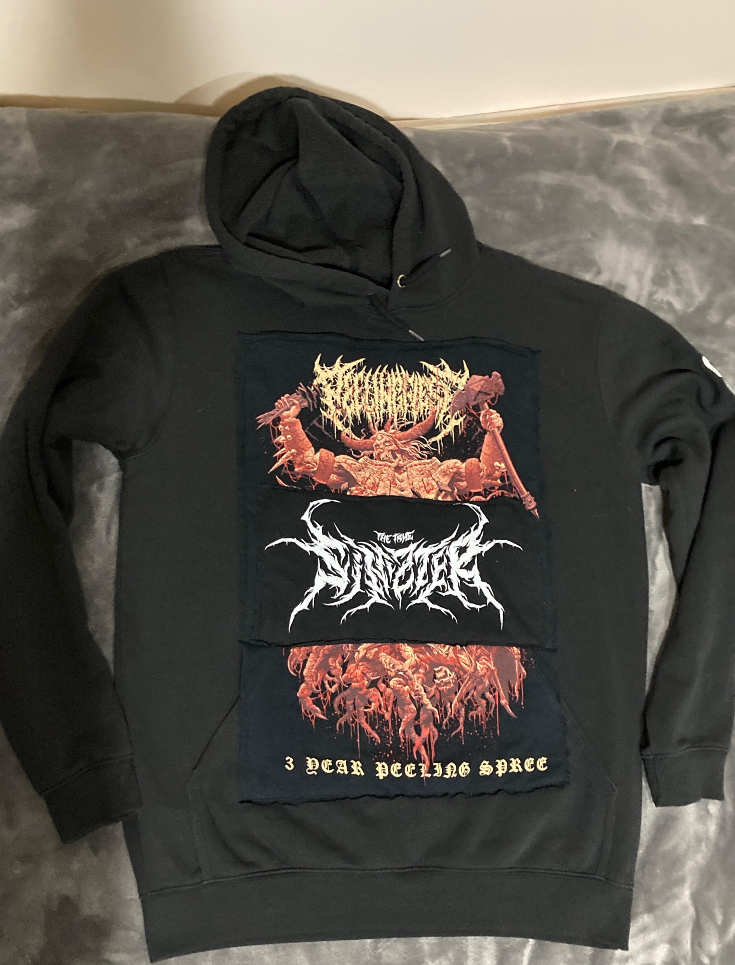 Black hoodie featuring three colorful patches covering original graphics.