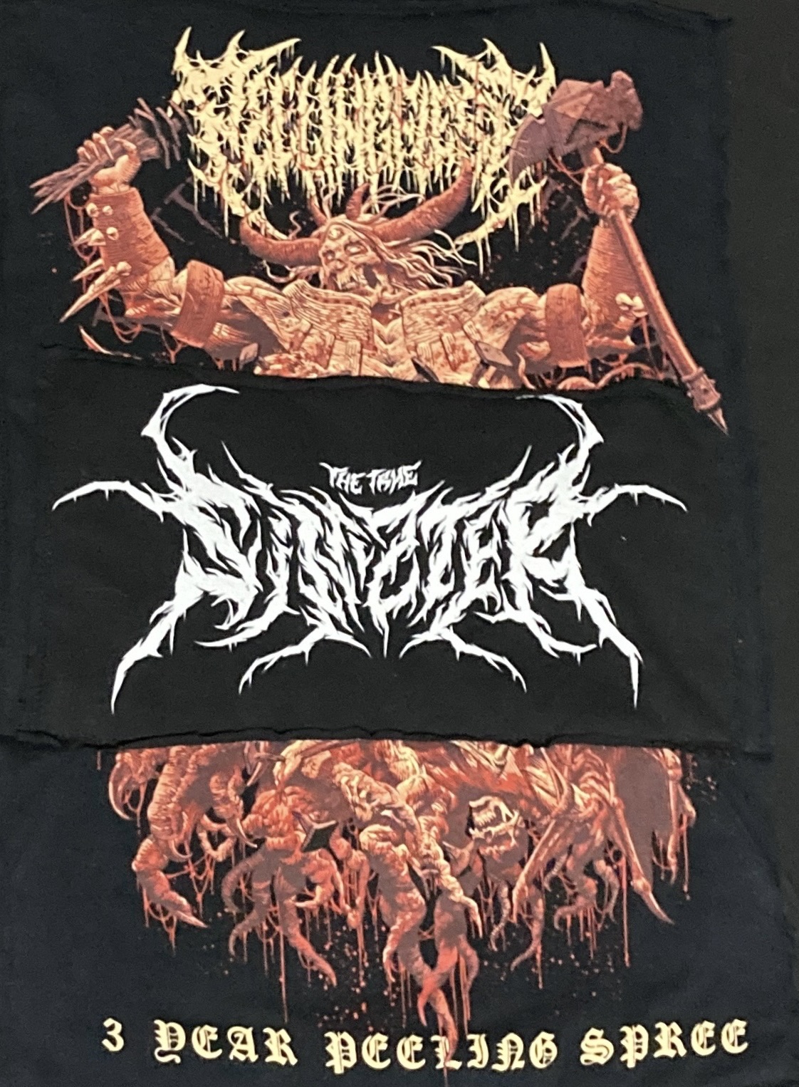 A close-up view of three fabric cutouts featuring intricate graphic designs, including band logos and illustrated characters, arranged together for repurposing on a hoodie.
